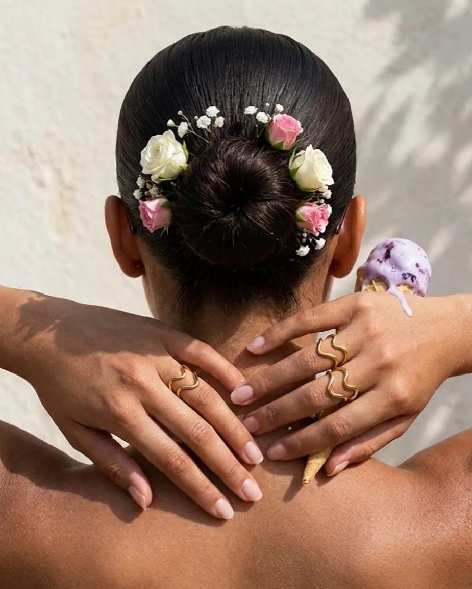 Bagues La Bohème portées, mains posées sur une nuque, chignon fleuri