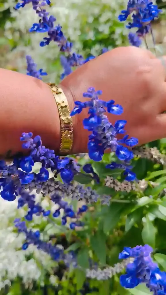 Le bracelet Lila au poignet, filmé en plein soleil devant un massif de sauges bleues